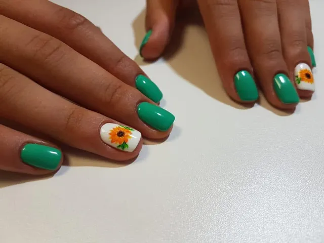 Manichiură verde smarald cu accent floral, floarea-soarelui